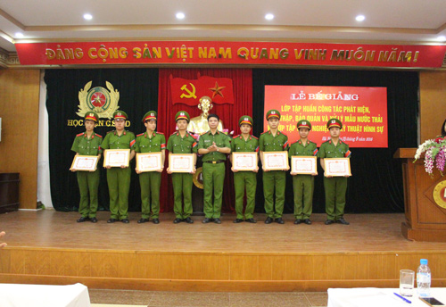 Đồng chí Đại tá Phạm Ngọc Cường, Giám đốc Trung tâm Bồi dưỡng chức danh và giáo viên, Học viện CSND trao Giấy khen của Giám đốc Học viện CSND cho các học viên có thành tích xuất sắc trong học tập và công tác quản lý lớp học